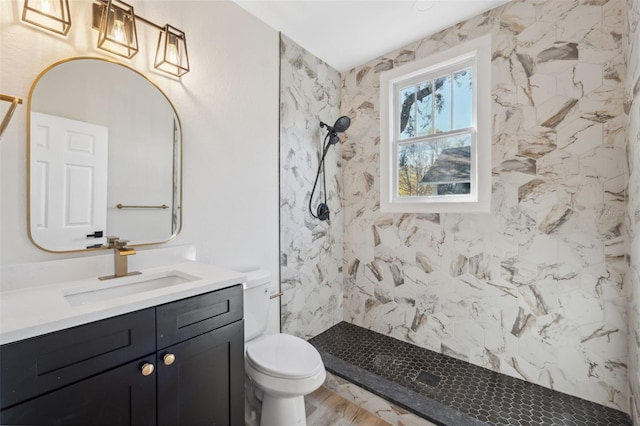 full bath featuring vanity, a marble finish shower, and toilet