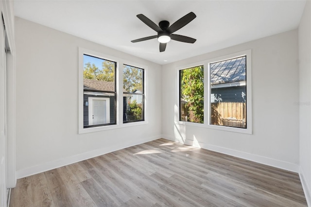 spare room with ceiling fan, wood finished floors, and baseboards