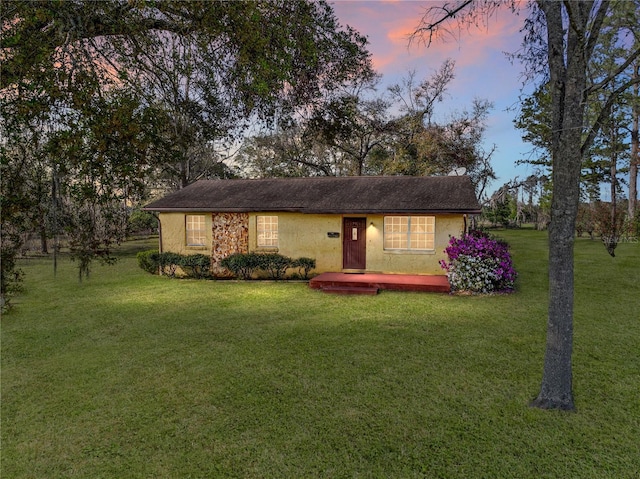 view of front of house with a yard and stucco siding