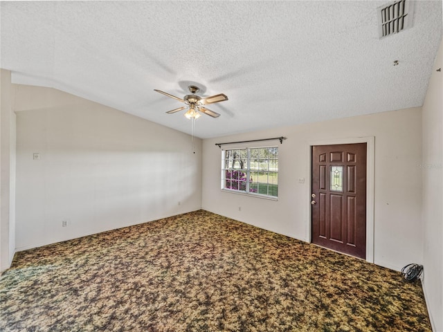 interior space with lofted ceiling, ceiling fan, a textured ceiling, visible vents, and carpet