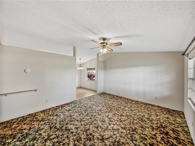 unfurnished room featuring carpet floors, a textured ceiling, a ceiling fan, and lofted ceiling