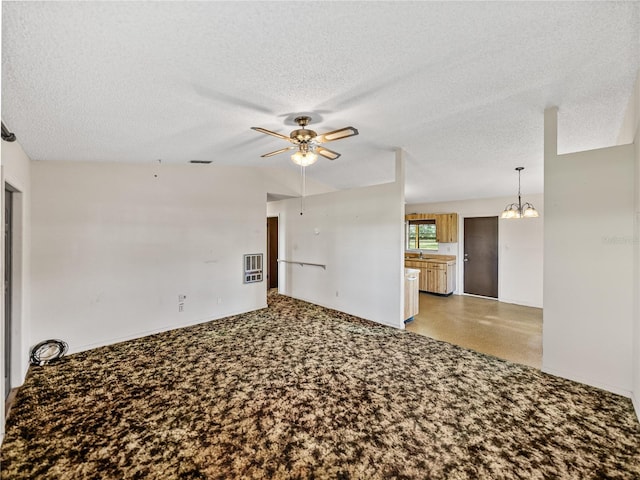 unfurnished living room featuring a textured ceiling, ceiling fan with notable chandelier, and visible vents