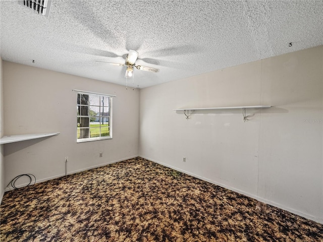 empty room with carpet, visible vents, ceiling fan, and a textured ceiling