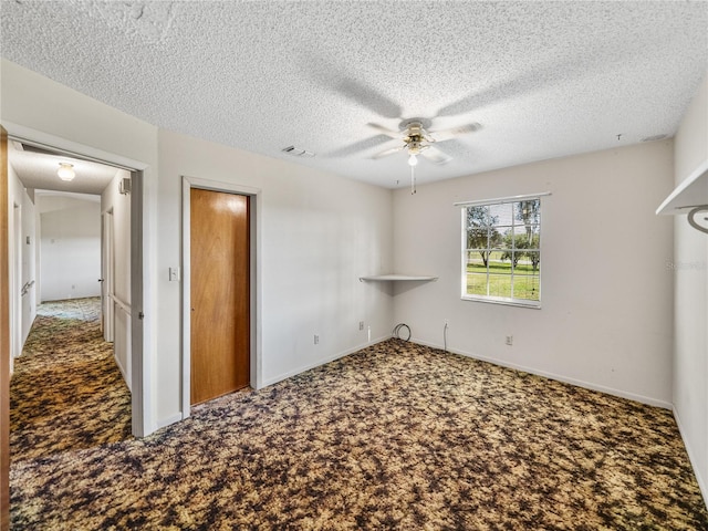 unfurnished bedroom featuring a textured ceiling, carpet flooring, a ceiling fan, and baseboards