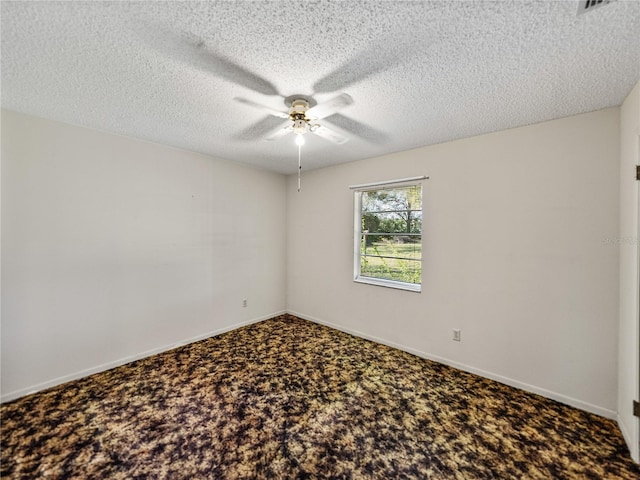 carpeted empty room featuring ceiling fan, baseboards, and a textured ceiling