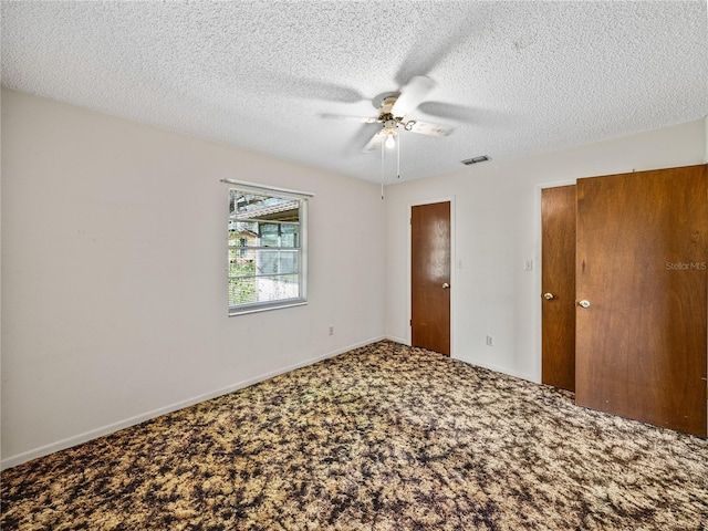 unfurnished bedroom featuring baseboards, visible vents, ceiling fan, carpet, and a textured ceiling