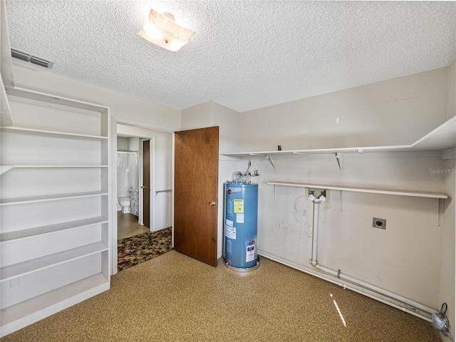 clothes washing area with a textured ceiling, electric water heater, hookup for an electric dryer, laundry area, and visible vents