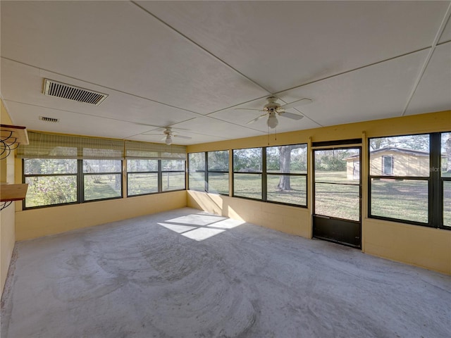 unfurnished sunroom featuring plenty of natural light, visible vents, and a ceiling fan