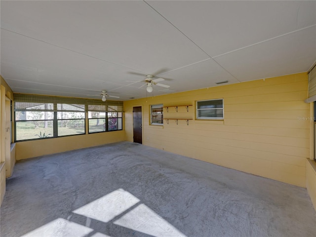 unfurnished sunroom featuring visible vents and a ceiling fan