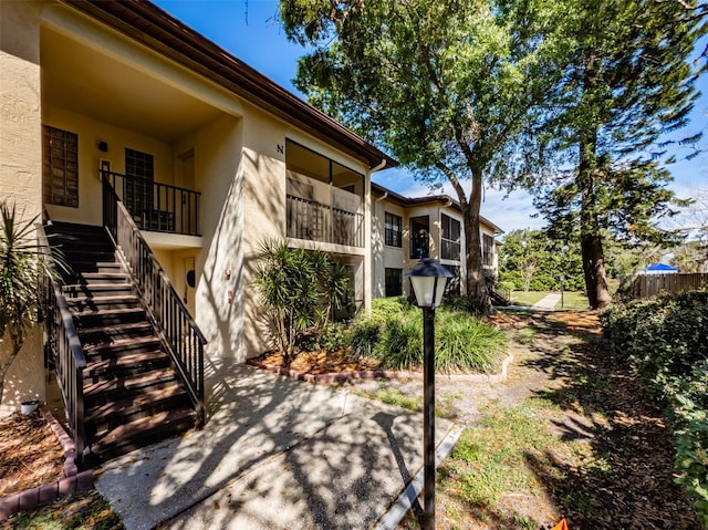 exterior space with stairs and stucco siding