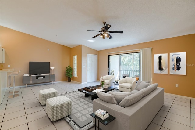 living room with lofted ceiling, a textured ceiling, light tile patterned flooring, and a ceiling fan