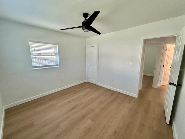 unfurnished bedroom featuring a closet, light wood-style flooring, and baseboards