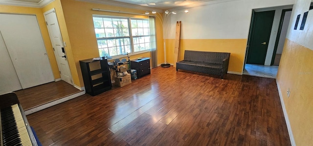 sitting room with ornamental molding and wood finished floors