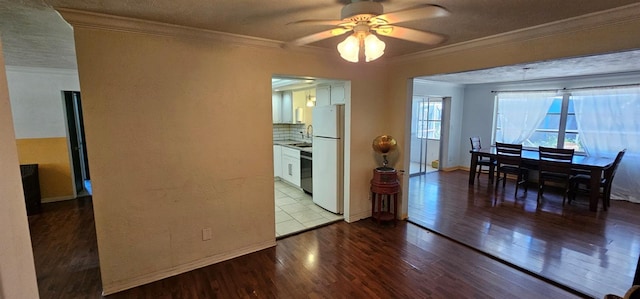 dining room with baseboards, a ceiling fan, ornamental molding, wood finished floors, and a textured ceiling