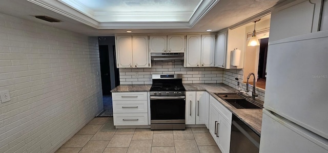 kitchen featuring stainless steel gas stove, visible vents, a raised ceiling, under cabinet range hood, and a sink