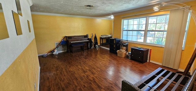 office with a textured ceiling, ornamental molding, wood finished floors, and visible vents