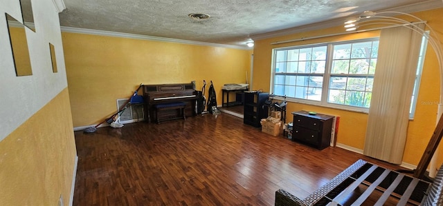 misc room with a textured ceiling, ornamental molding, and wood finished floors