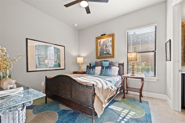 bedroom featuring light tile patterned floors, a ceiling fan, and baseboards