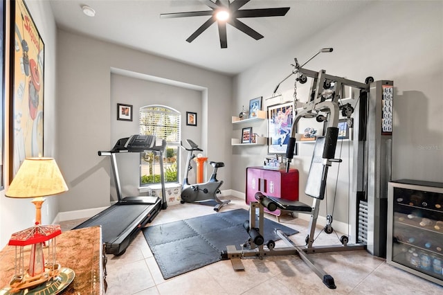 workout room with tile patterned floors, baseboards, and ceiling fan