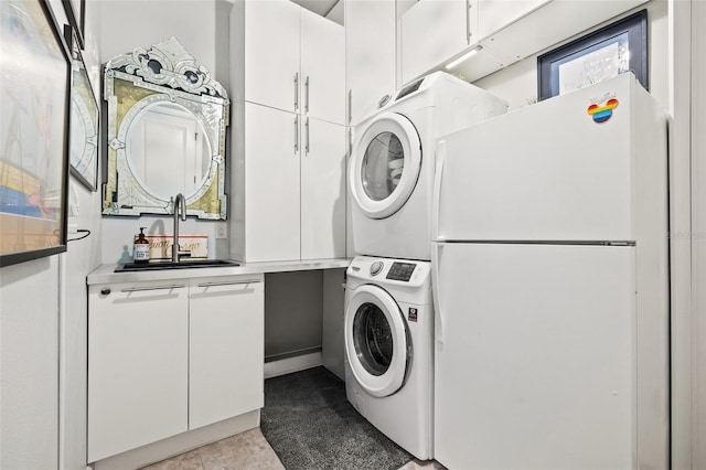 washroom featuring a sink, stacked washer / drying machine, and cabinet space