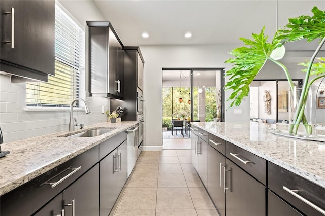 kitchen featuring backsplash, recessed lighting, appliances with stainless steel finishes, light tile patterned flooring, and a sink