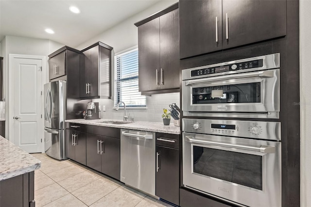 kitchen with tasteful backsplash, light tile patterned floors, recessed lighting, appliances with stainless steel finishes, and a sink