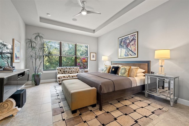 bedroom with light tile patterned floors, baseboards, a raised ceiling, and ceiling fan