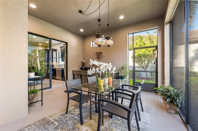 dining space with recessed lighting, finished concrete floors, and a textured wall