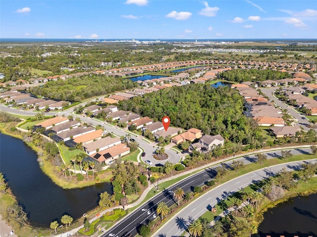 drone / aerial view with a water view and a residential view