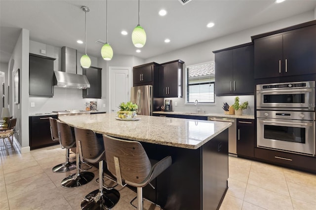 9708 Highland Park Pl, Palmetto, FL 34221 - kitchen with stainless steel appliances, a center island, a breakfast bar area, recessed lighting, and decorative light fixtures