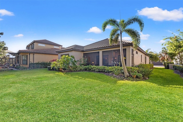9708 Highland Park Pl, Palmetto, FL 34221 - rear view of house with a tile roof, a yard, stucco siding, and a sunroom