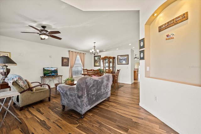 living area with ceiling fan with notable chandelier and wood finished floors