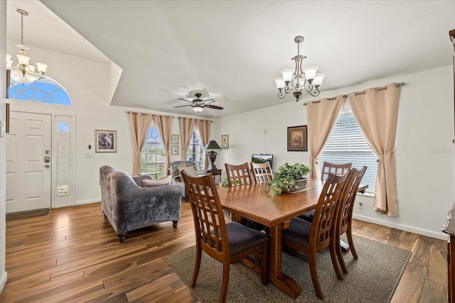 dining space featuring baseboards, hardwood / wood-style floors, and ceiling fan with notable chandelier