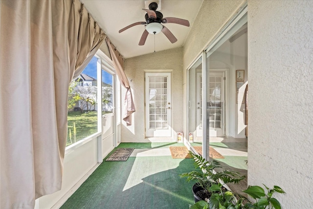 unfurnished sunroom featuring a ceiling fan and vaulted ceiling