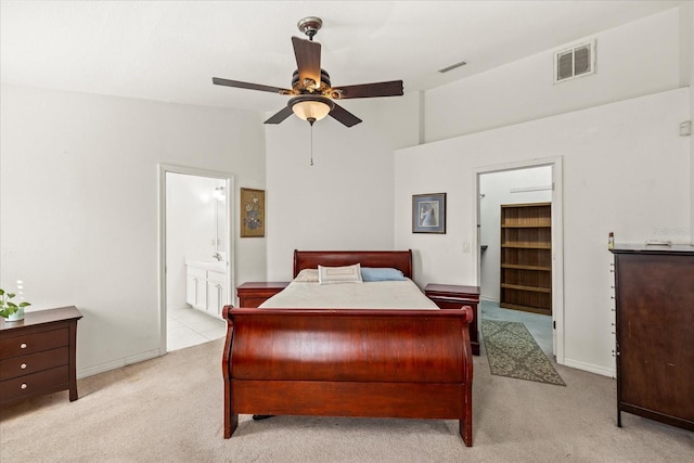 carpeted bedroom with lofted ceiling, visible vents, ceiling fan, and ensuite bathroom