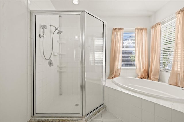 bathroom featuring a stall shower, tile patterned flooring, and a bath