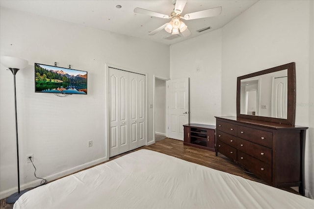 bedroom featuring baseboards, visible vents, a ceiling fan, wood finished floors, and a closet