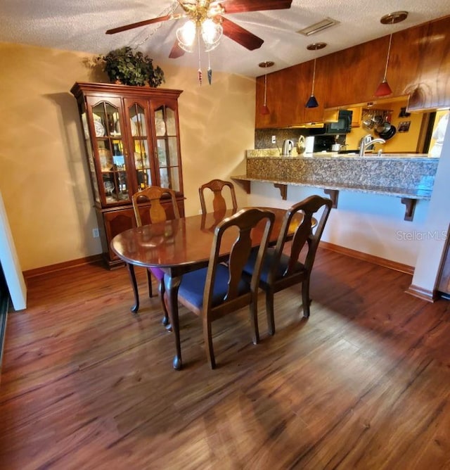 dining room with ceiling fan, wood finished floors, and baseboards