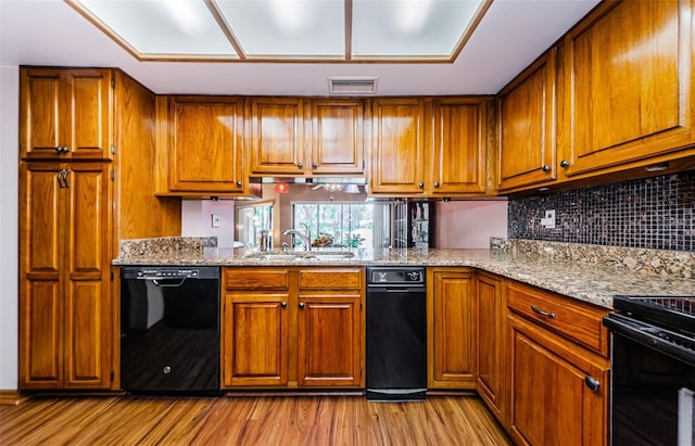 kitchen featuring brown cabinets, visible vents, a sink, and black appliances