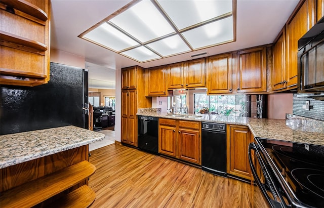 kitchen featuring open shelves, black appliances, a sink, and brown cabinets