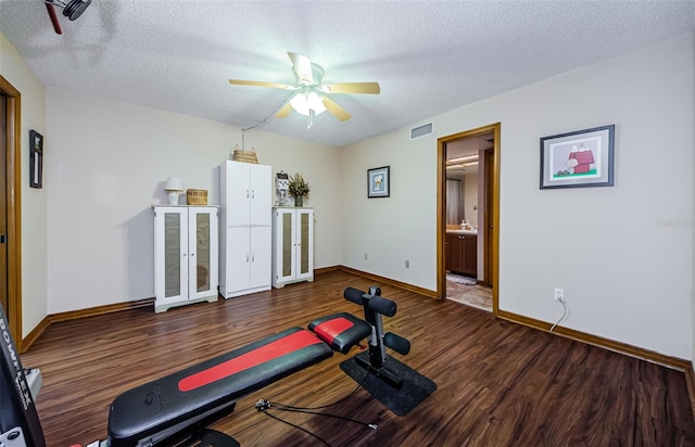 workout room with visible vents, ceiling fan, a textured ceiling, wood finished floors, and baseboards