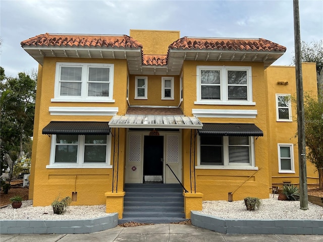 view of front of house featuring entry steps, a tile roof, and stucco siding