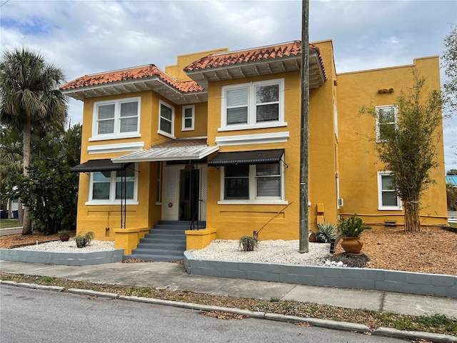 view of front of home with a tiled roof and stucco siding