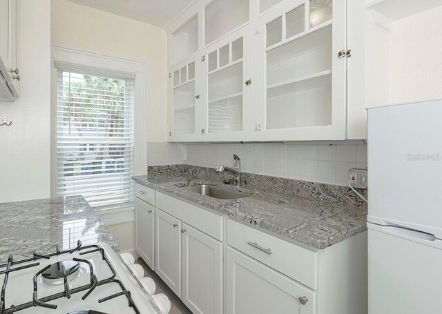 kitchen featuring white cabinetry, a sink, and decorative backsplash