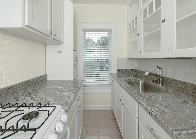 kitchen featuring white cabinetry, a sink, and backsplash