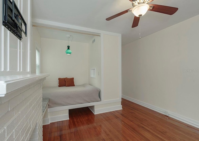 bedroom with a ceiling fan, baseboards, and wood finished floors