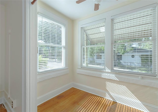 interior space featuring light wood finished floors, a ceiling fan, and baseboards