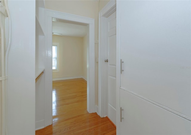 corridor with light wood-style floors and baseboards
