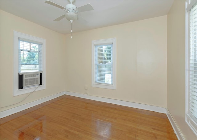 unfurnished room featuring ceiling fan, light wood finished floors, cooling unit, and baseboards