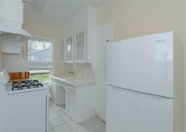 kitchen featuring light tile patterned floors, light countertops, white appliances, and white cabinets